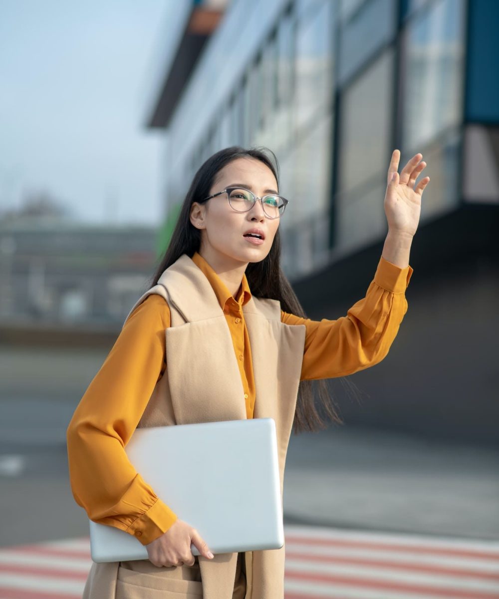 young asian pretty woman waving her hand on the road